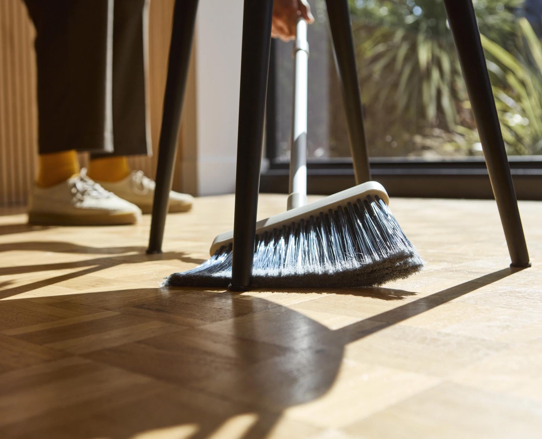 Eleganter CleanTech Besen in modernem Steinfarbton, ideal für die Reinigung und mit praktischer Wandhalterung zur einfachen Aufbewahrung.