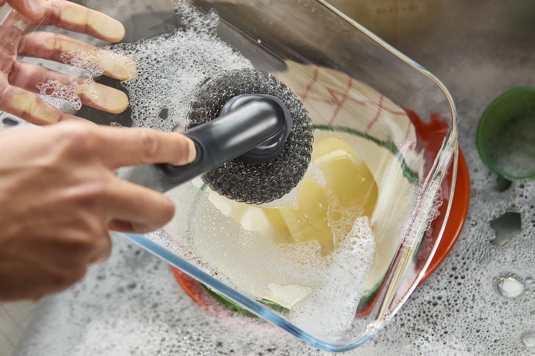Praktische SinkTech Spülbürste mit integriertem Seifenspender und zusätzlichem Ersatzkopf, ideal für effizientes Abwaschen in der Küche.