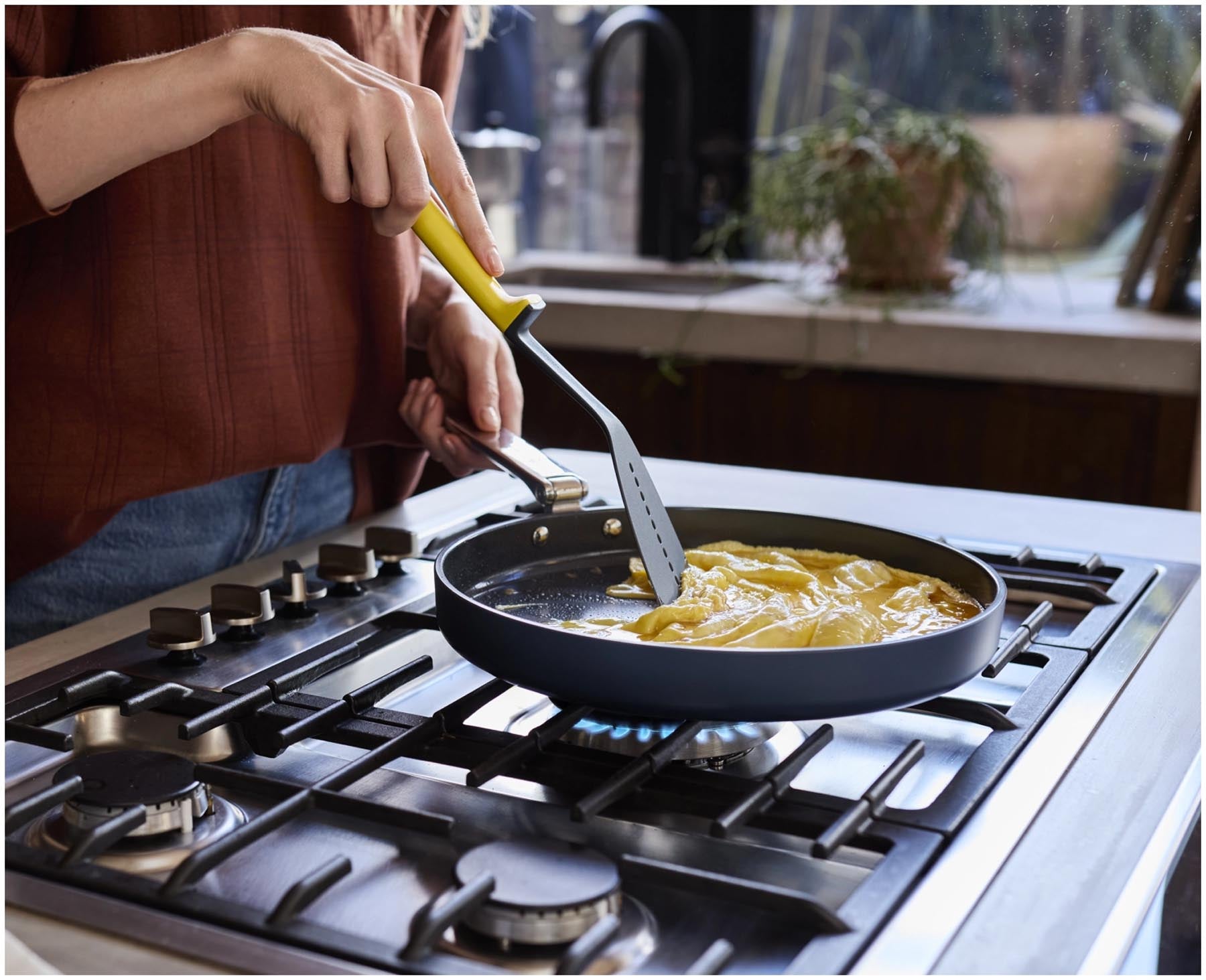 Moderne flache Bratpfanne D28cm von Joseph Joseph mit innovativem Klappgriff, perfekt für effizientes Kochen und ansprechende Präsentation.