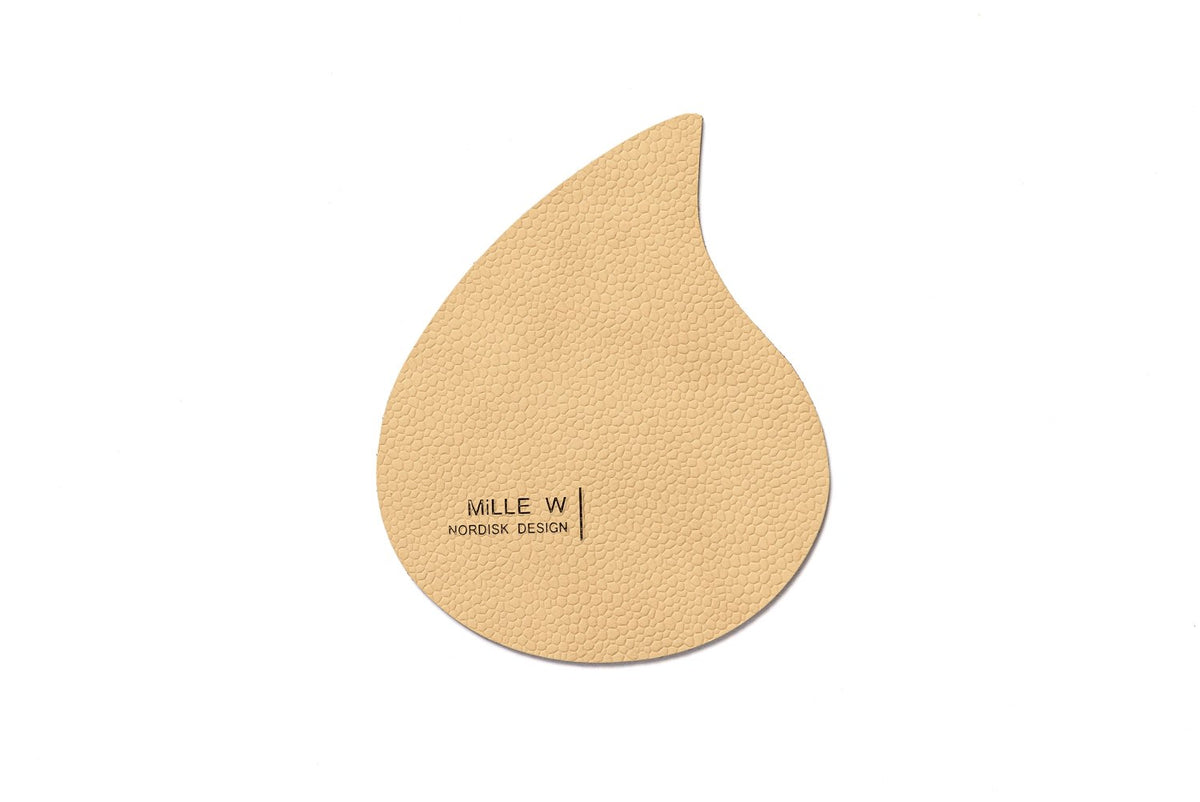 Beiger Pfannenuntersatz in Tropfenform, Masse 12x10x0.2 cm, mit Artikelnummer 7350004350544 von MiLLE W NORDISK DESIGN auf hellem Hintergrund.