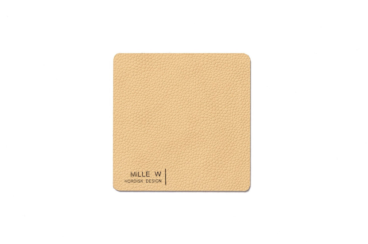 Rechteckiger Untersetzer in Beige von MiLLE W NORDISK DESIGN, flache Form, Grösse 10x10x0.2 cm, als Pfannenuntersatz auf heller Fläche liegend.