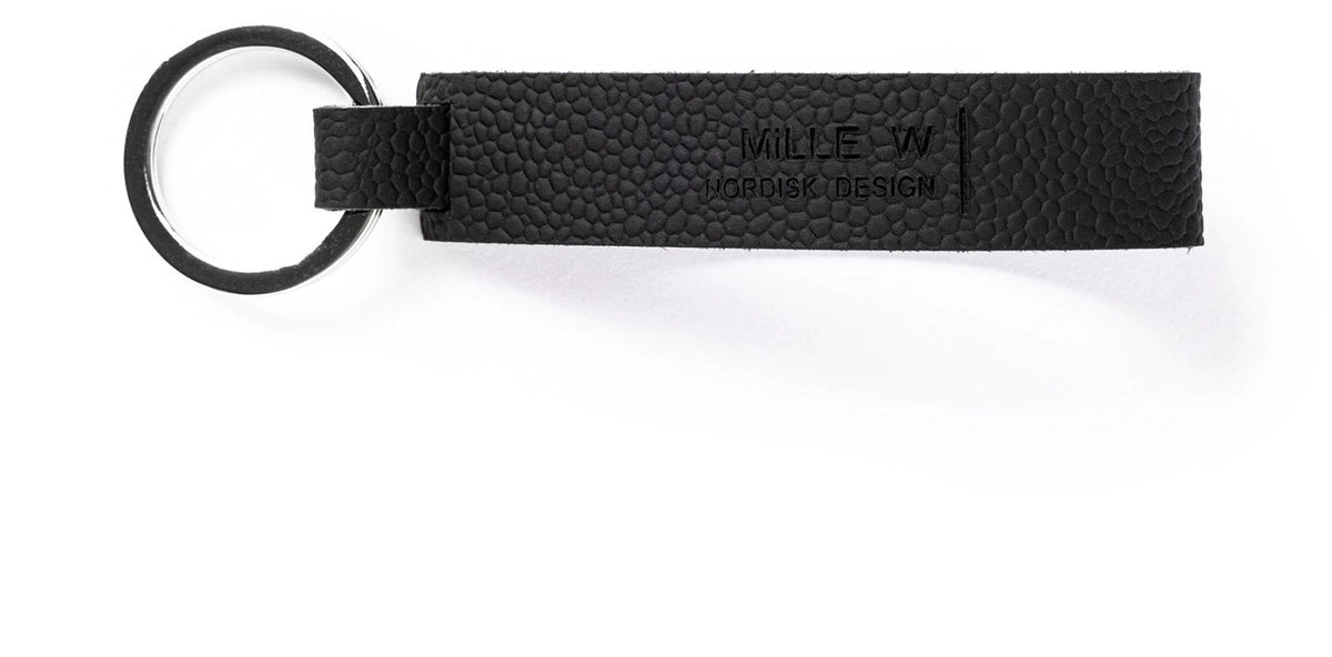 Schwarzer Schlüsselanhänger classic nickel schwarz von MiLLE W NORDISK DESIGN, schlanke rechteckige Form, Masse 8 x 2 x 0.2 cm, auf hellem Hintergrund.
