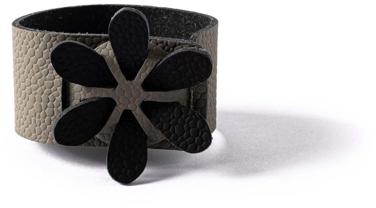 Grauer Serviettenring in Blumenform, Masse 7x7x4cm, mit Artikelnummer 7350004350780 von MiLLE W NORDISK DESIGN auf hellem Hintergrund.