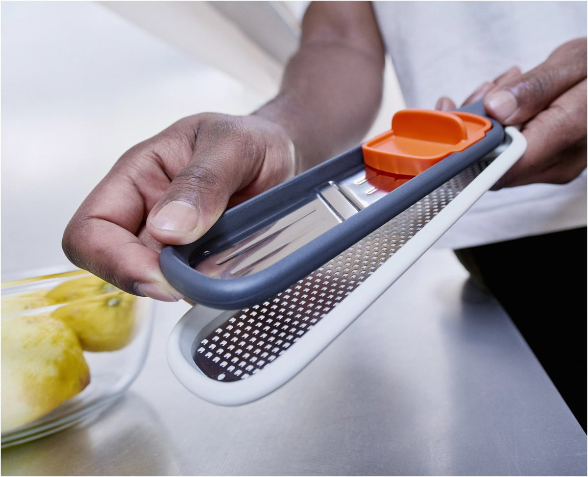 Graues Joseph Joseph Nest Slice & Zest Set aus Mini-Mandoline und Zestenreibe mit Stachelhalter und Schutzhülle, kompakt zusammengeklipst