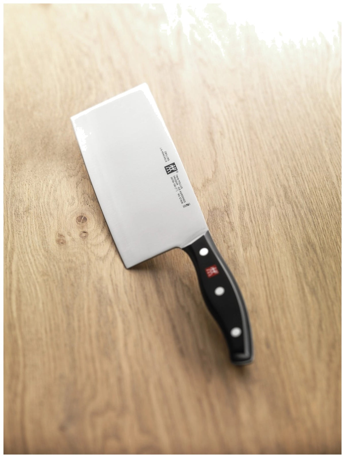 Zwilling Signature Kochmesser mit 18cm hoher Klinge aus Edelstahl, Griff im Drei-Nieten-Design, mehrfarbige Optik, Ansicht von der Seite.