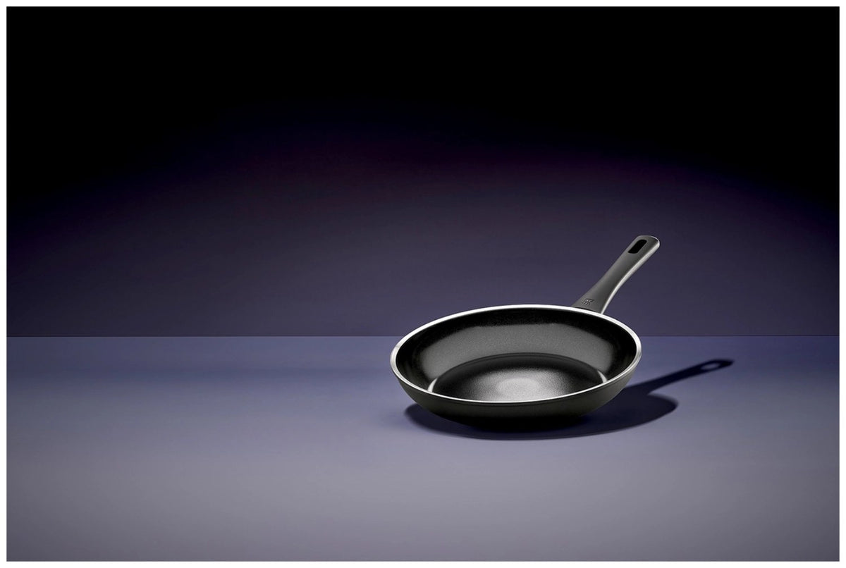 Schwarze Aluminium-Bratpfanne mit 24cm Durchmesser, Keramikbeschichtung, Temperaturindikator in der Pfannenmitte und flachem Induktionsboden.