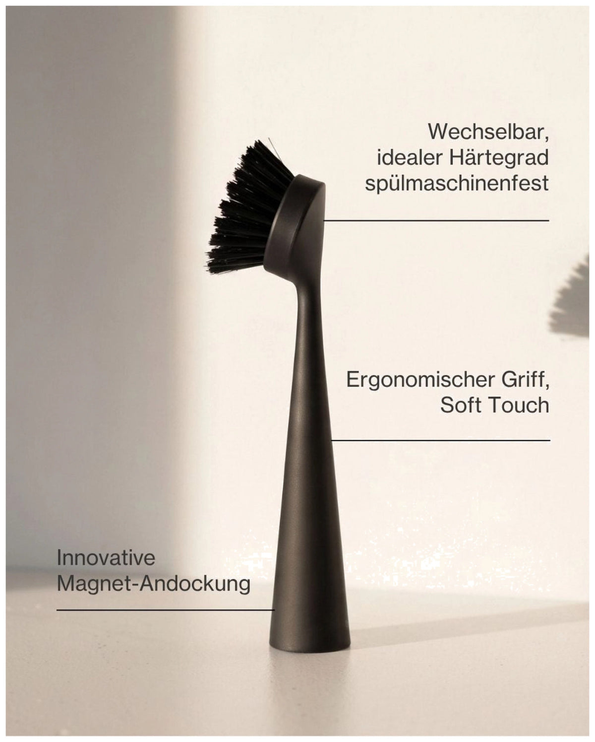 Schwarze Spülbürste aus Kunststoff von Nordesign mit schlankem Griff, wechselbarem Bürstenkopf und integriertem Magnet an der Unterseite.