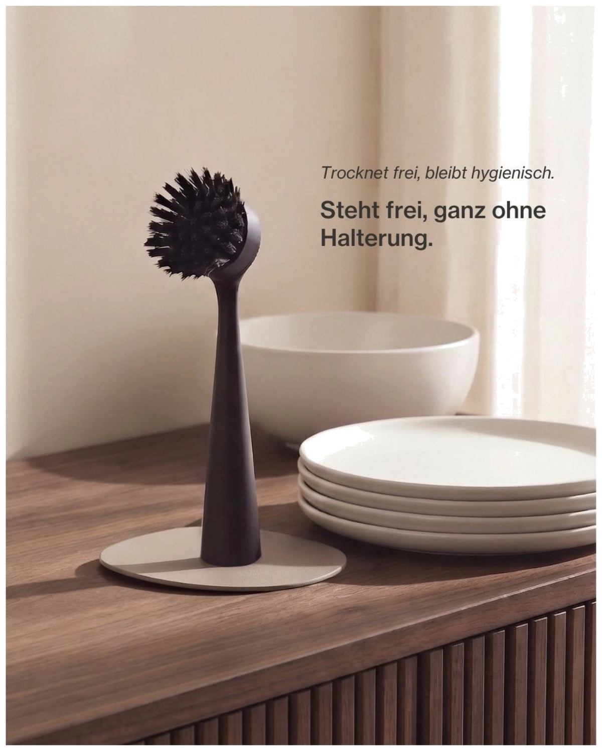 Schwarze Spülbürste aus Kunststoff von Nordesign mit schlankem Griff, wechselbarem Bürstenkopf und integriertem Magnet an der Unterseite.