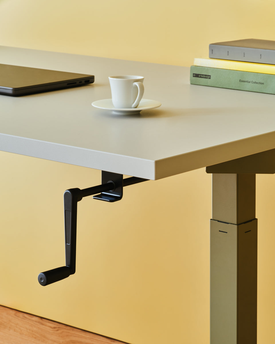 Eleganter Ogi Drive BOC02 Schreibtisch mit manuellem Höhenverstellmechanismus, ideal für ergonomisches Arbeiten und ansprechende Büros.