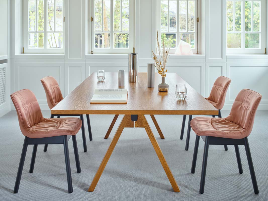 Stuhl Baltic 2 Soft Duo von Mdd mit gepolstertem Sitz, drapiertem Kissen und vier Holzfüssen aus Buchenholz in Dunkelgrau.
