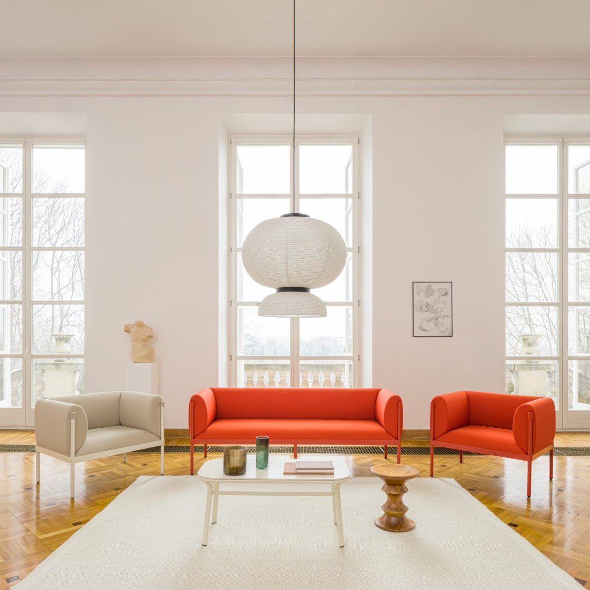 Elegantes 2er-Sofa Stilt SIS2 mit niedriger Rückenlehne, ideal für moderne Wohnräume. Helle Polsterung und stilvolle Holzbeine verleihen Charme.