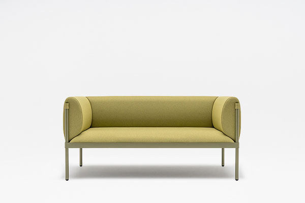 Dunkelblaues Sofa Stilt mit gepolsterter niedriger Rückenlehne, Armlehnen und vierbeinigem Stahlgestell auf hellem Hintergrund.
