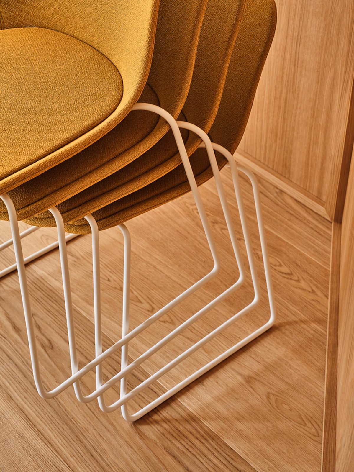Stuhl Baltic 2 Classic von Mdd mit gepolstertem Ziegelrot-Sitz, gefälteltem Kissen und stapelbarem Drahtkufen-Gestell in Beige.