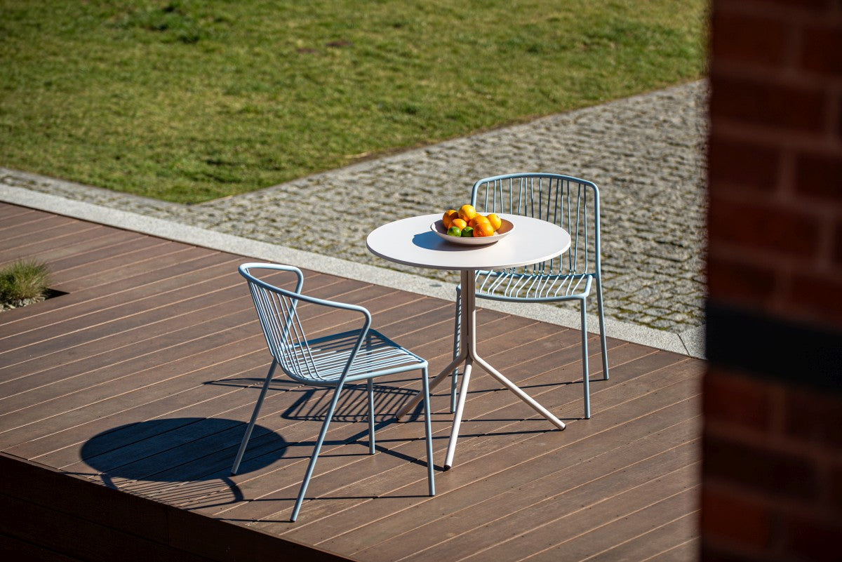 Runder Cafeteriatisch Luna mit ziegelroter, pulverbeschichteter Stahlplatte und dreibeinigem Stahlrohrgestell, Ø 70 cm, Höhe 73 cm.