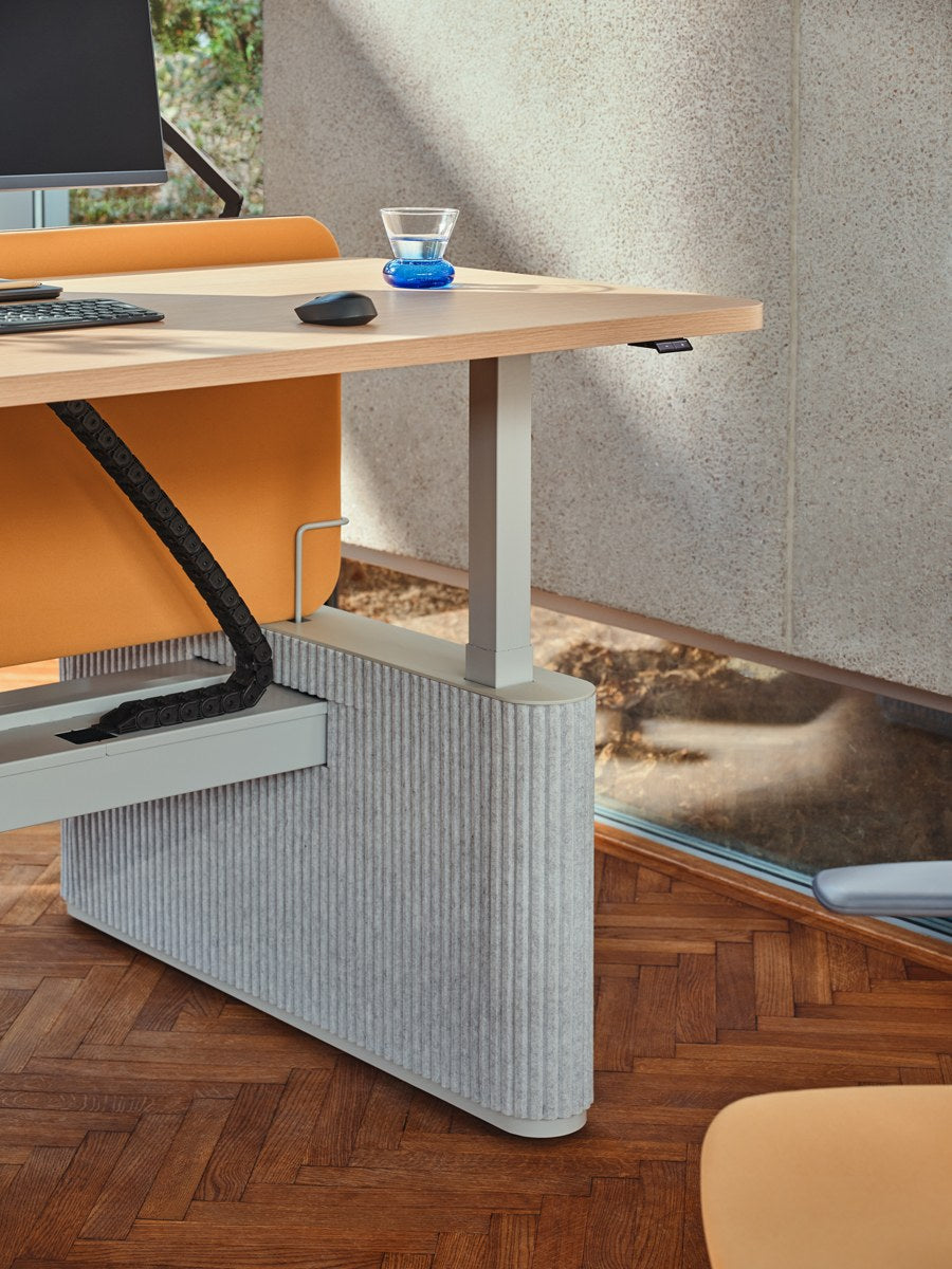 Bench-Schreibtisch Ogi Drive mit zwei Tischplatten, elektrisch höhenverstellbarem Metallgestell und Fusselementen aus PET-Filz in Anthrazit.