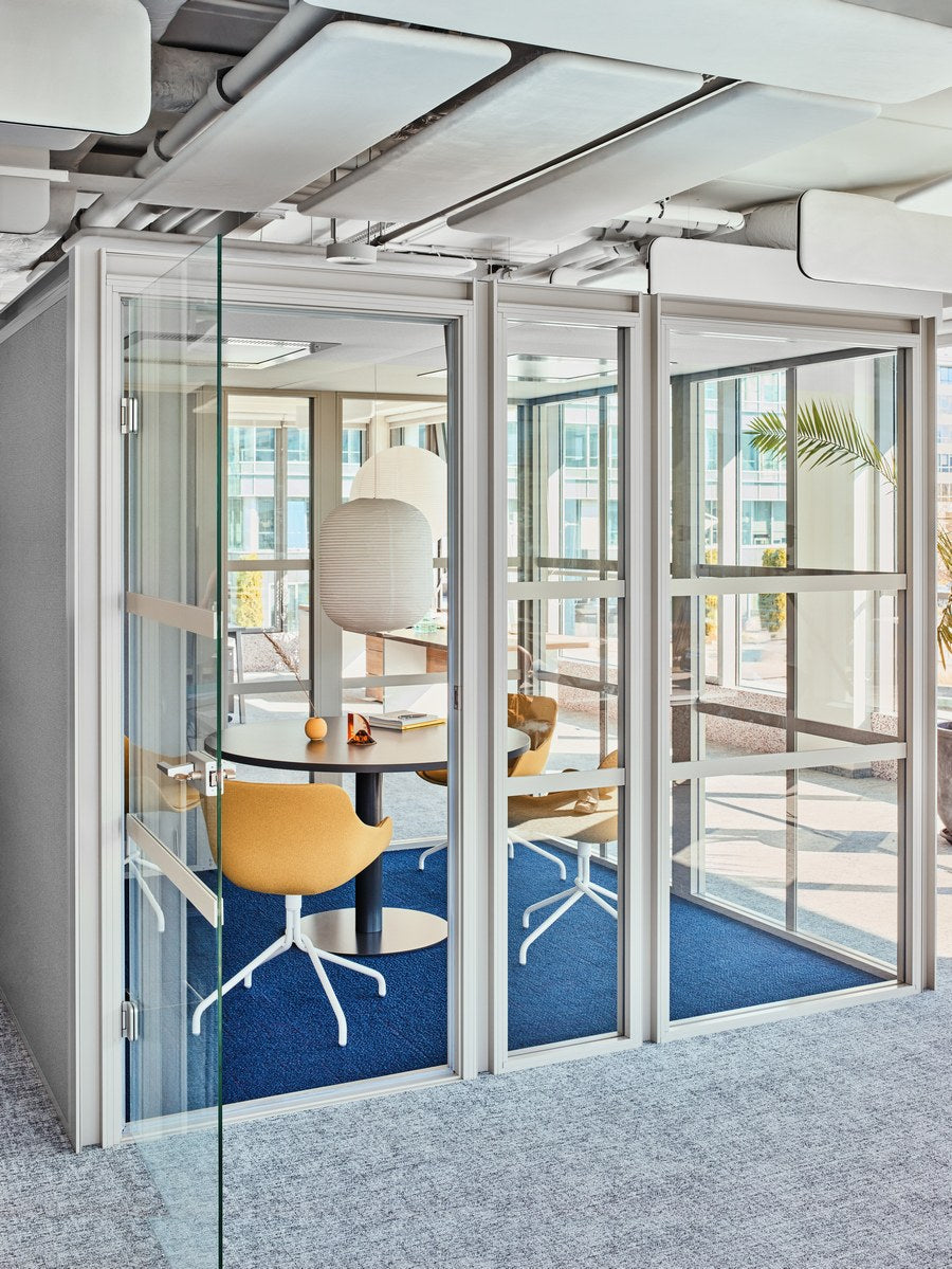 Freistehende Meeting-Akustikkabine Hako Meeting XL in Anthrazit Halbmatt mit Glaswänden, gepolsterten Wänden und Metallgestell für Gruppen.