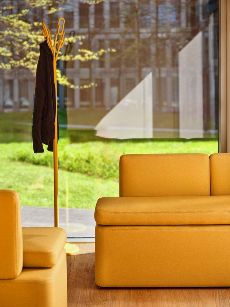 Niedriges modulares Sofa Kaiva von Mdd in Dunkelgrau mit gepolstertem Holzrahmen und geometrischer Rückenlehne, freigestellt.