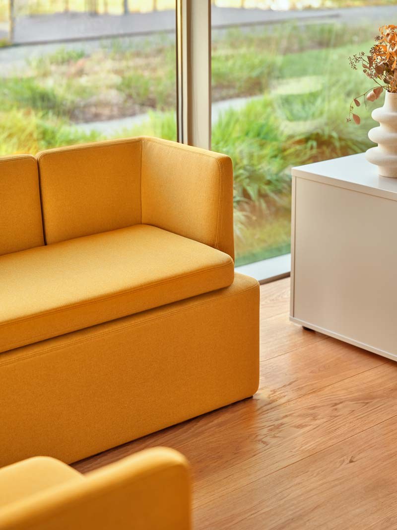 Niedriges modulares Sofa Kaiva von Mdd in Dunkelgrau mit gepolstertem Holzrahmen und geometrischer Rückenlehne, freigestellt.