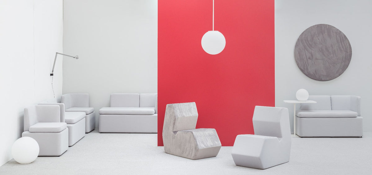Niedriges modulares Sofa Kaiva von Mdd in Dunkelgrau mit gepolstertem Holzrahmen und geometrischer Rückenlehne, freigestellt.