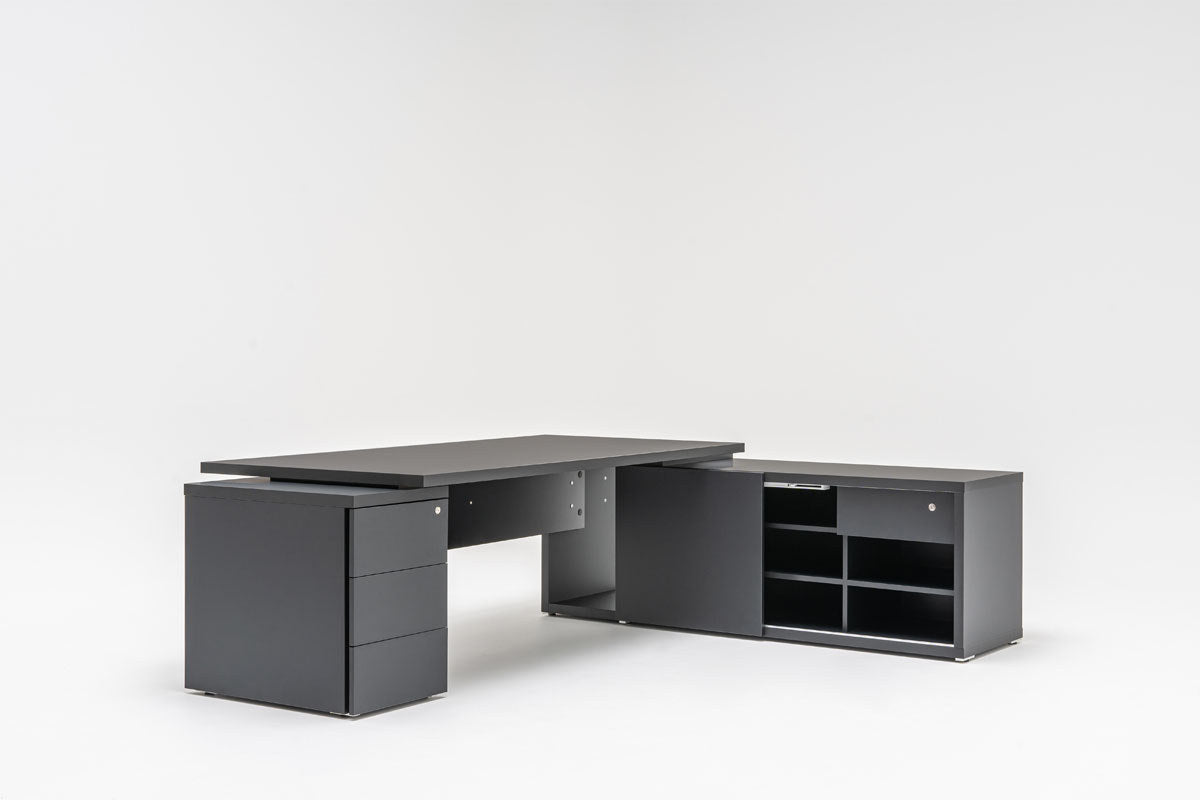 Chefschreibtisch Mito von Mdd in Bernsteineiche mit HPL-Wangenfuss in schwarz oder weiss, Melaminplatte mit ABS-Umleimer, rechteckige Form.