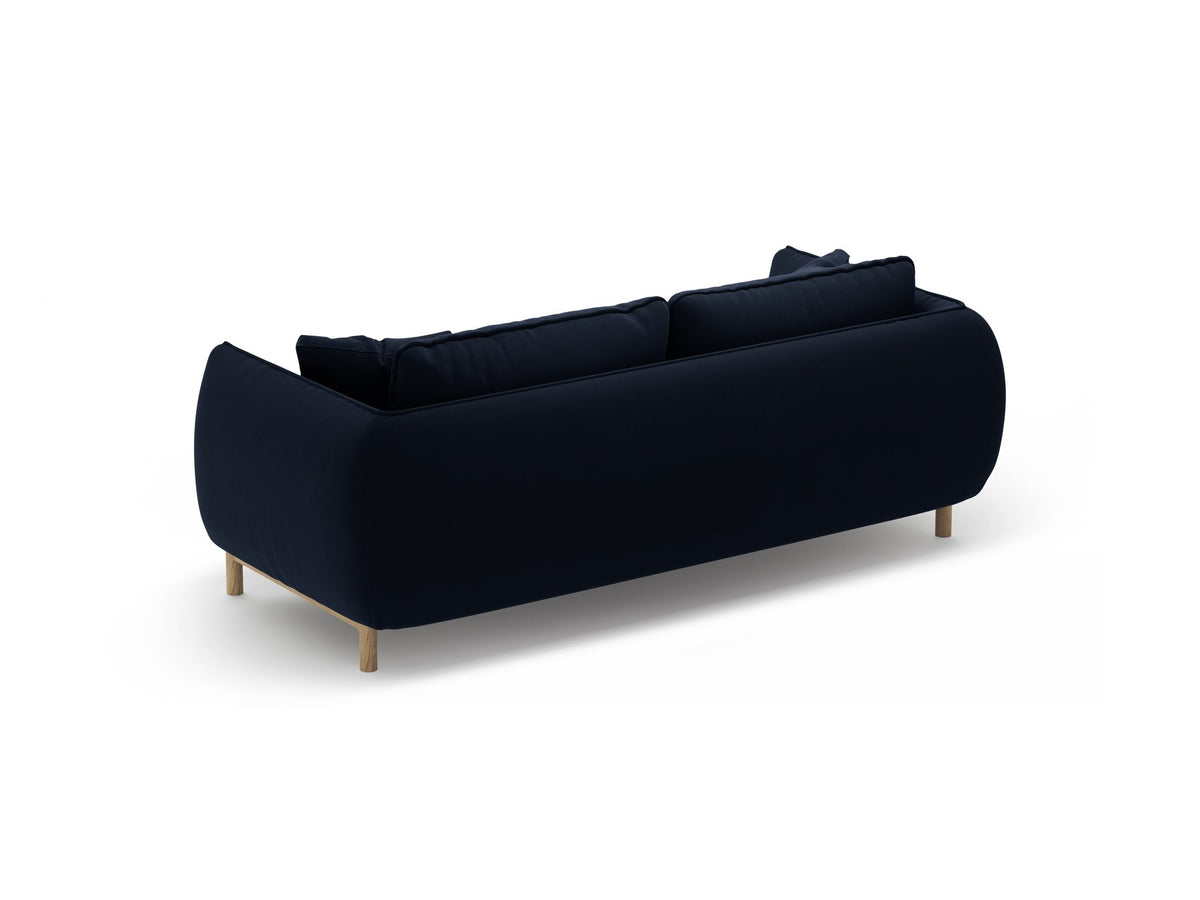 Ada 2er Sofa von Micadoni in Mandel beige mit gepolstertem Velours-Bezug, geschwungener Rückenlehne und sichtbaren Buchenholzbeinen.