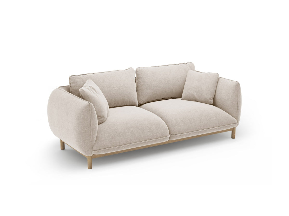 Ada 2er Sofa von Micadoni in Mandel beige mit gepolstertem Velours-Bezug, geschwungener Rückenlehne und sichtbaren Buchenholzbeinen.
