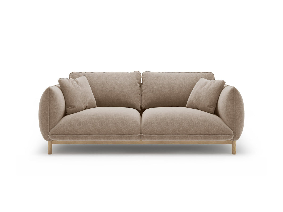 Ada 2er Sofa von Micadoni in Mandel beige mit gepolstertem Velours-Bezug, geschwungener Rückenlehne und sichtbaren Buchenholzbeinen.