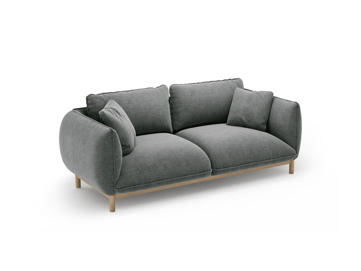 Ada 2er Sofa von Micadoni in Mandel beige mit gepolstertem Velours-Bezug, geschwungener Rückenlehne und sichtbaren Buchenholzbeinen.