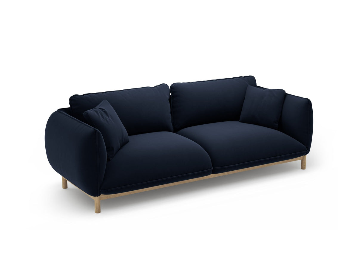 Dreisitzer-Sofa Ada von Micadoni mit geschwungener Form, Casino-Velours-Bezug in Mandel Beige und Buchenholzbeinen.