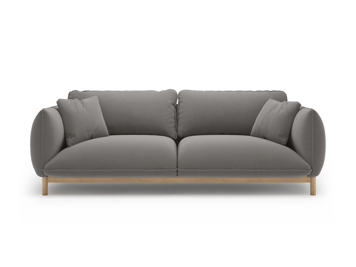 Dreisitzer-Sofa Ada von Micadoni mit geschwungener Form, Casino-Velours-Bezug in Mandel Beige und Buchenholzbeinen.