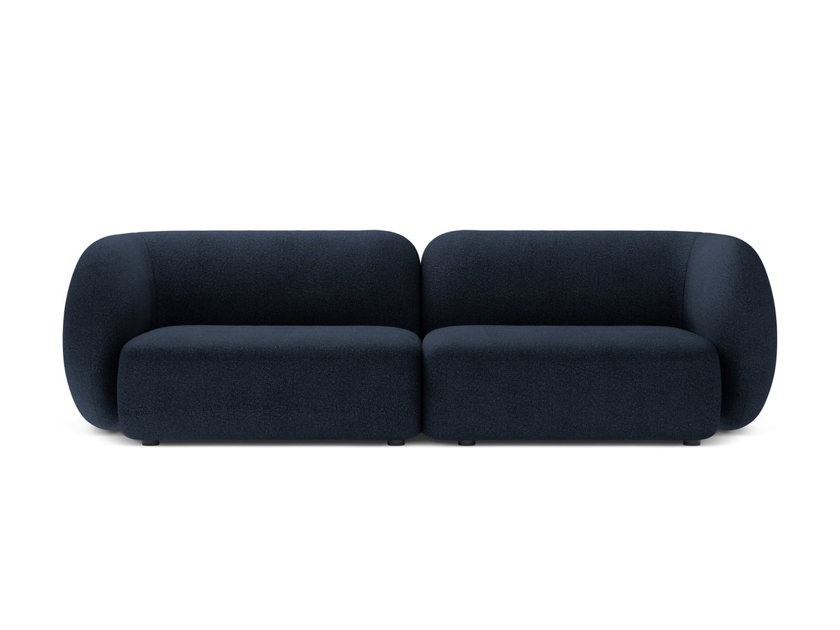 Weisses 4er Sofa Kate von Micadoni mit strukturiertem Bouclé-Stoff, schwarzen Kunststoffbeinen und breiter Sitzfläche.
