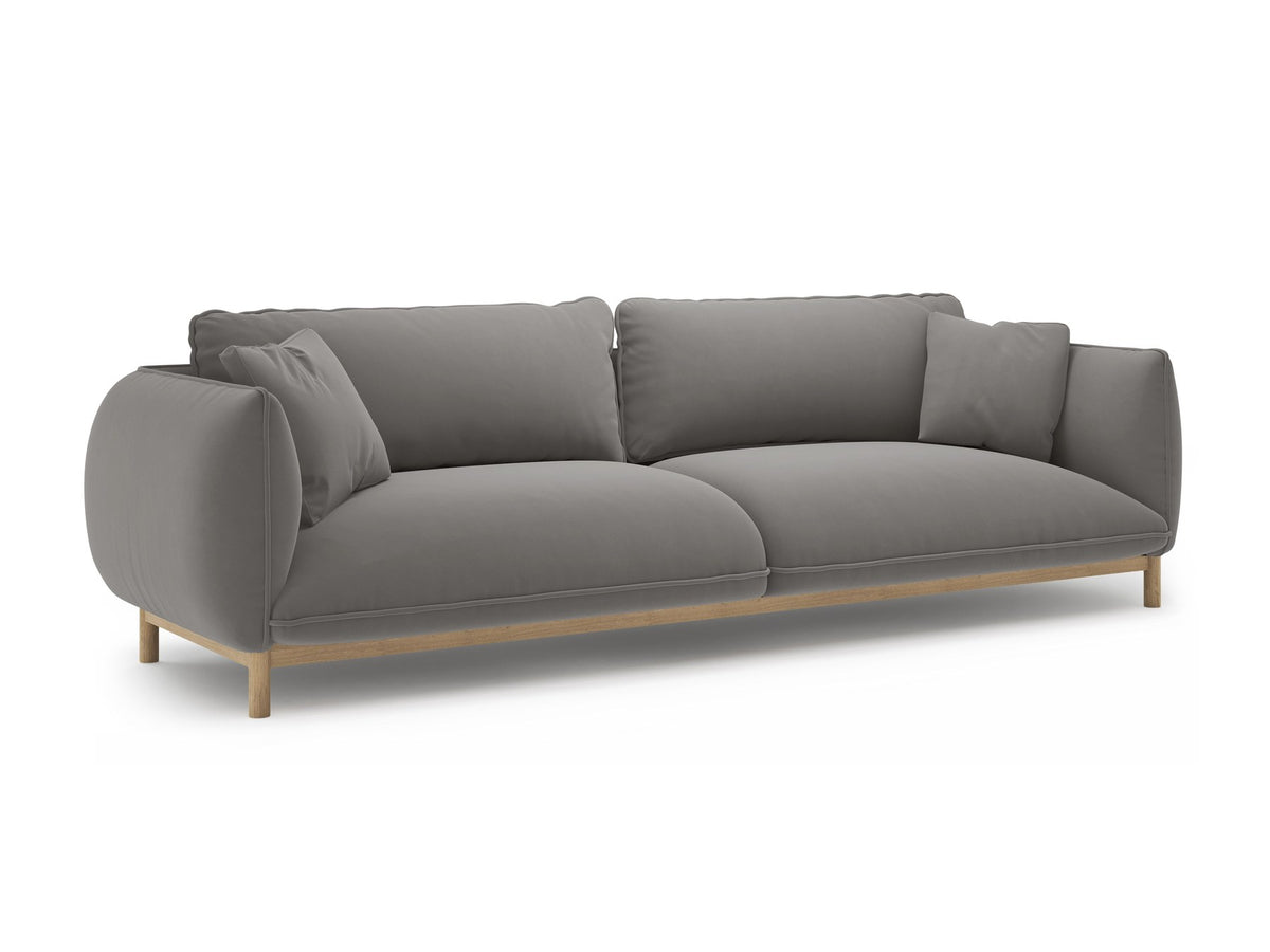 Vierersofa Ada von Micadoni in Mandel beige mit Casino-Stoffbezug, gerundeten Armlehnen und sichtbarem Buchenholzgestell auf Holzbeinen.