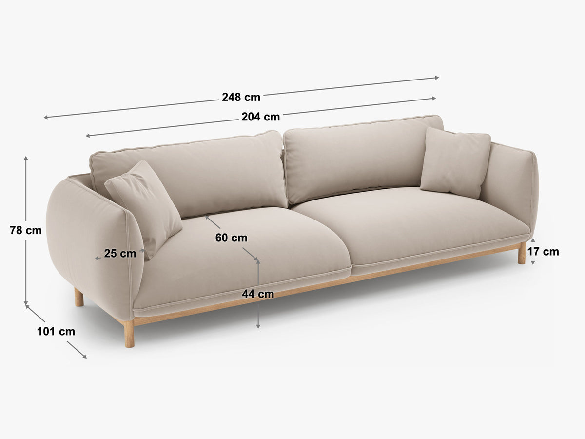 Vierersofa Ada von Micadoni in Mandel beige mit Casino-Stoffbezug, gerundeten Armlehnen und sichtbarem Buchenholzgestell auf Holzbeinen.