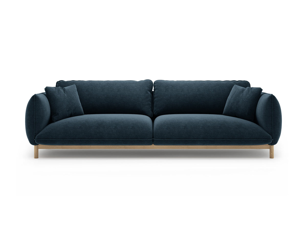 Vierersofa Ada von Micadoni in Mandel beige mit Casino-Stoffbezug, gerundeten Armlehnen und sichtbarem Buchenholzgestell auf Holzbeinen.