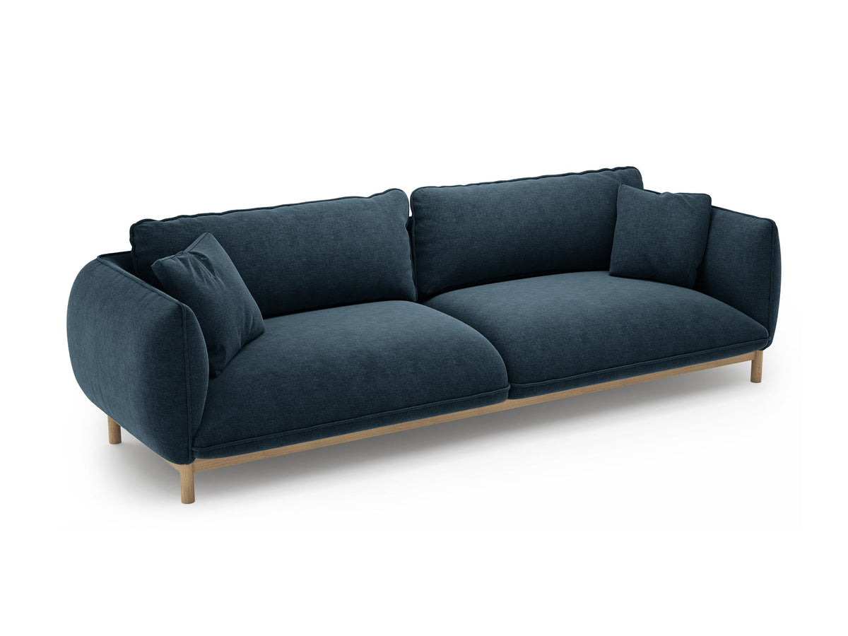 Vierersofa Ada von Micadoni in Mandel beige mit Casino-Stoffbezug, gerundeten Armlehnen und sichtbarem Buchenholzgestell auf Holzbeinen.