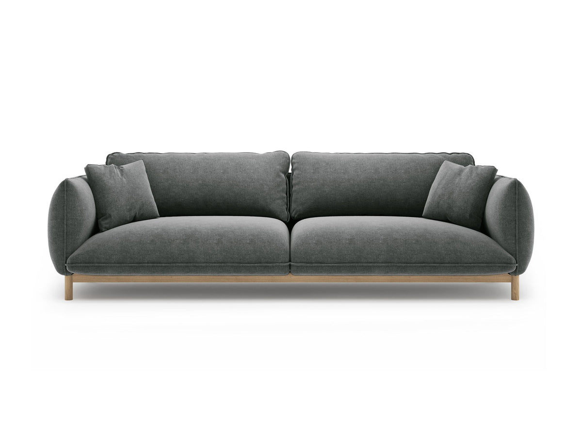 Vierersofa Ada von Micadoni in Mandel beige mit Casino-Stoffbezug, gerundeten Armlehnen und sichtbarem Buchenholzgestell auf Holzbeinen.