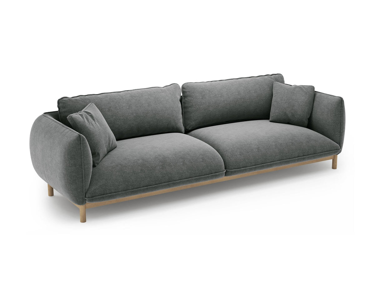 Vierersofa Ada von Micadoni in Mandel beige mit Casino-Stoffbezug, gerundeten Armlehnen und sichtbarem Buchenholzgestell auf Holzbeinen.