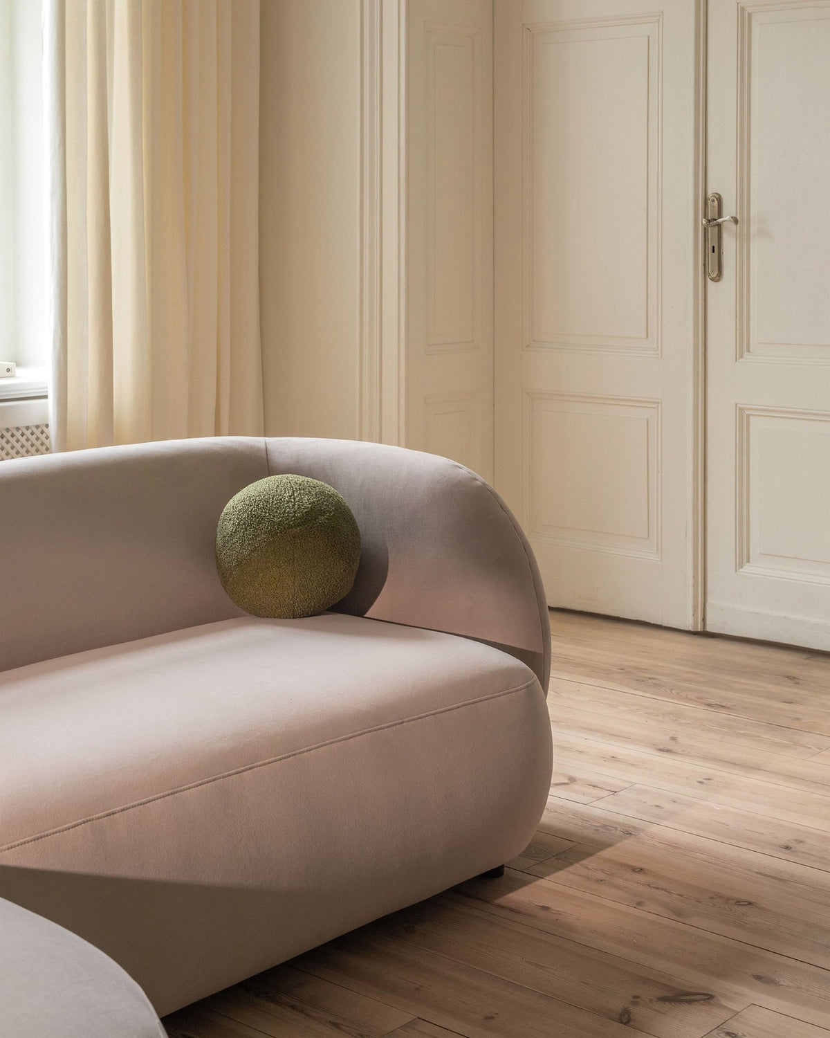 Weisses 4er Sofa Kate von Micadoni mit strukturiertem Bouclé-Stoff, schwarzen Kunststoffbeinen und breiter Sitzfläche.
