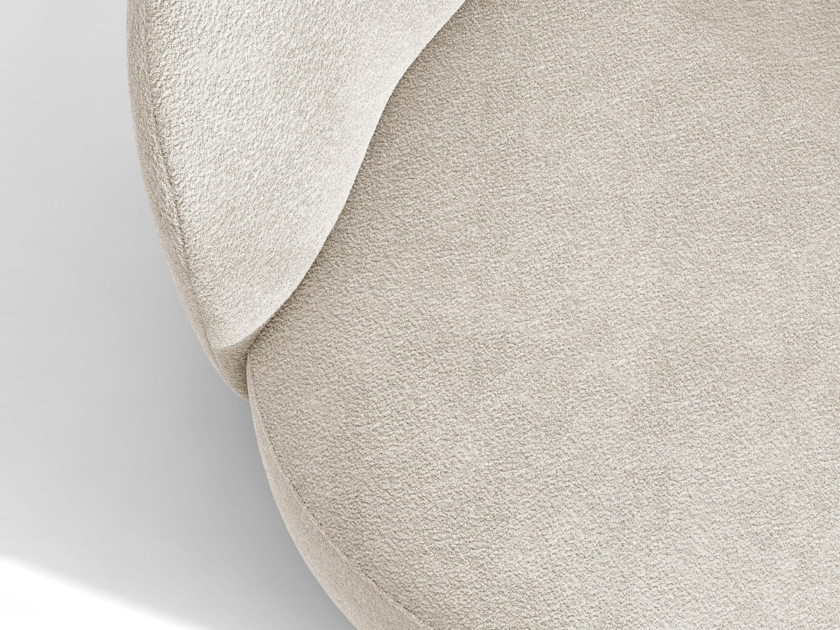 Drehbarer Sessel Letizia in leichtem Beige mit Chenille-Stoffbezug, gepolsterter Sitzfläche und niedrigen, stoffbezogenen Beinen.