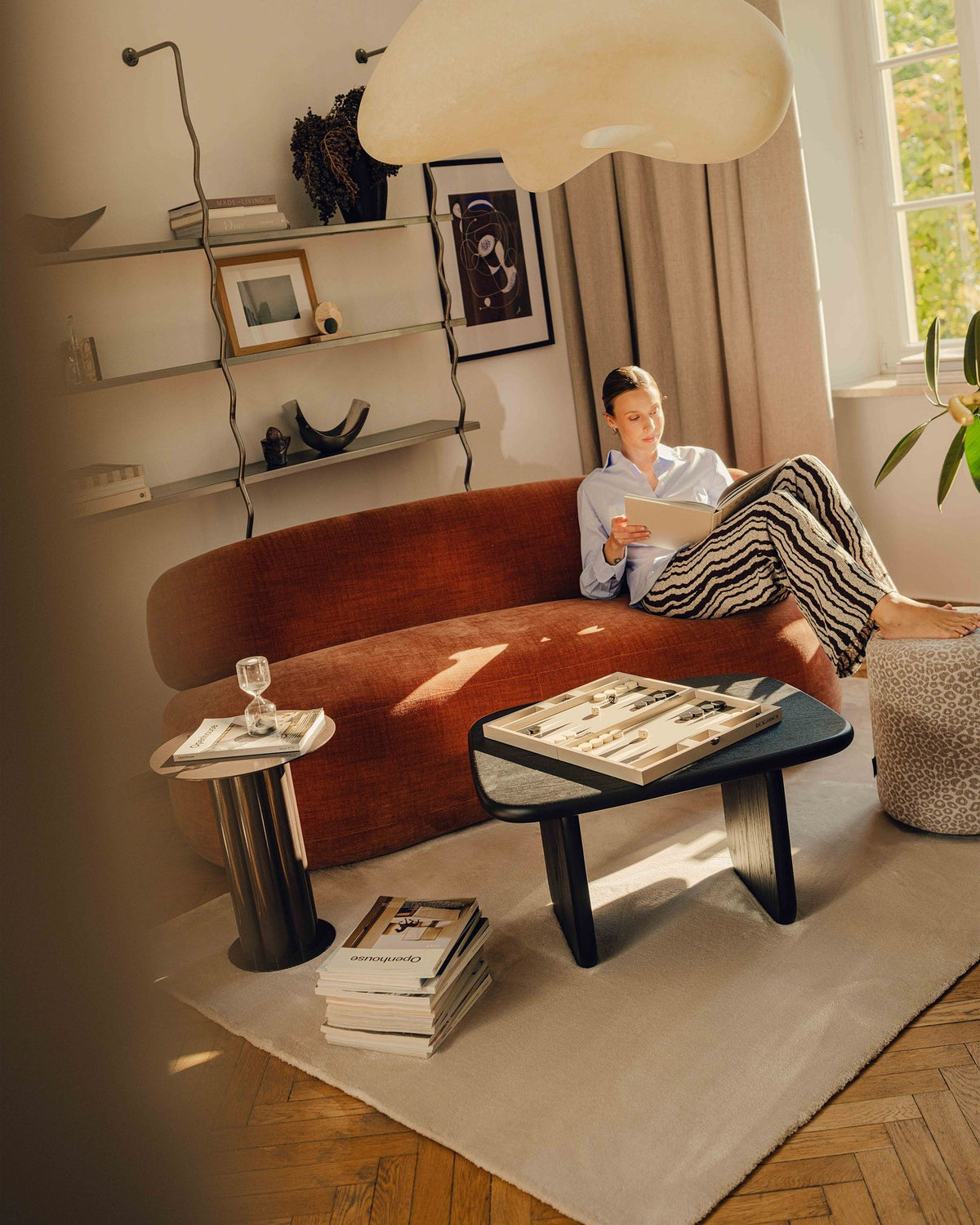 Drehbarer Sessel Aura von Micadoni mit gepolsterter Sitzfläche in Leichtes beige, Chenille-Stoff und schwarzem Stahlgestell auf Drehteller.