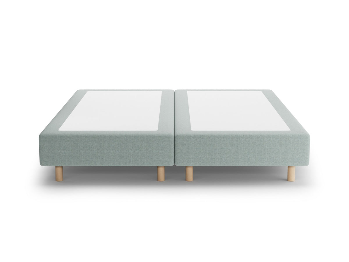 Bettgestell Whale von Micadoni in leichtem Beige, Chenille-Stoff Eden, Buchenholzbeine, ohne Kopfteil, Ansicht von schräg vorne.