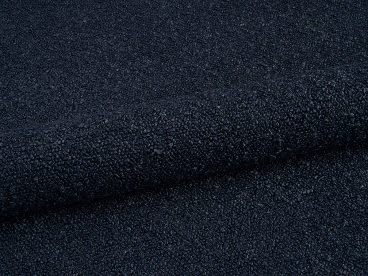 Weisse Sitzbank Dia von Micadoni mit gepolstertem Bouclé-Bezug, schwarzen Kunststoffbeinen und kompaktem, rechteckigem Design.