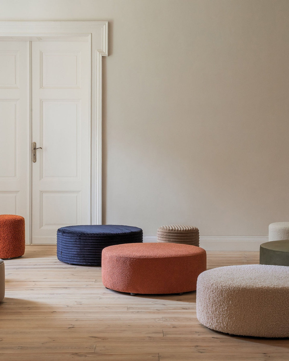 Weisse Sitzbank Dia von Micadoni mit gepolstertem Bouclé-Bezug, schwarzen Kunststoffbeinen und kompaktem, rechteckigem Design.