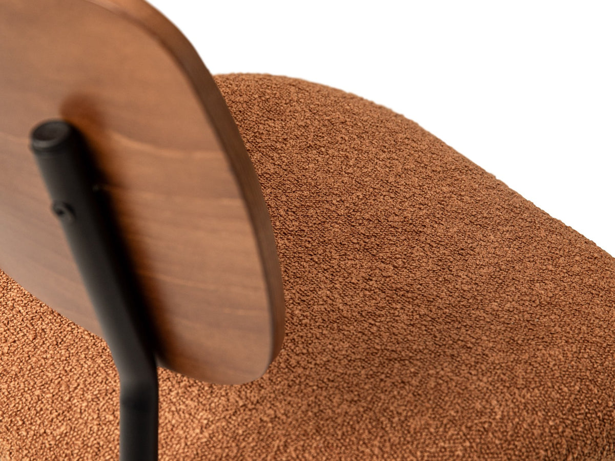 Beiger Samtstuhl mit gepolstertem Sitz aus Bouclé-Stoff, ergonomischer Rückenlehne aus Buchenholz und schwarzen Stahlbeinen im Esszimmer.