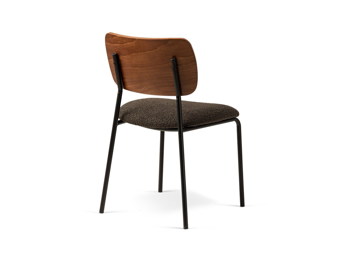 Beiger Samtstuhl mit gepolstertem Sitz aus Bouclé-Stoff, ergonomischer Rückenlehne aus Buchenholz und schwarzen Stahlbeinen im Esszimmer.