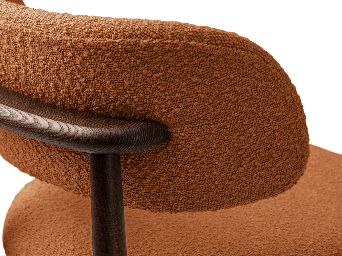 Beige gepolsterter Stuhl mit dick strukturiertem Bouclé-Stoff, gerader Rückenlehne und vier Beinen aus Nussbaumholz, Frontalansicht.