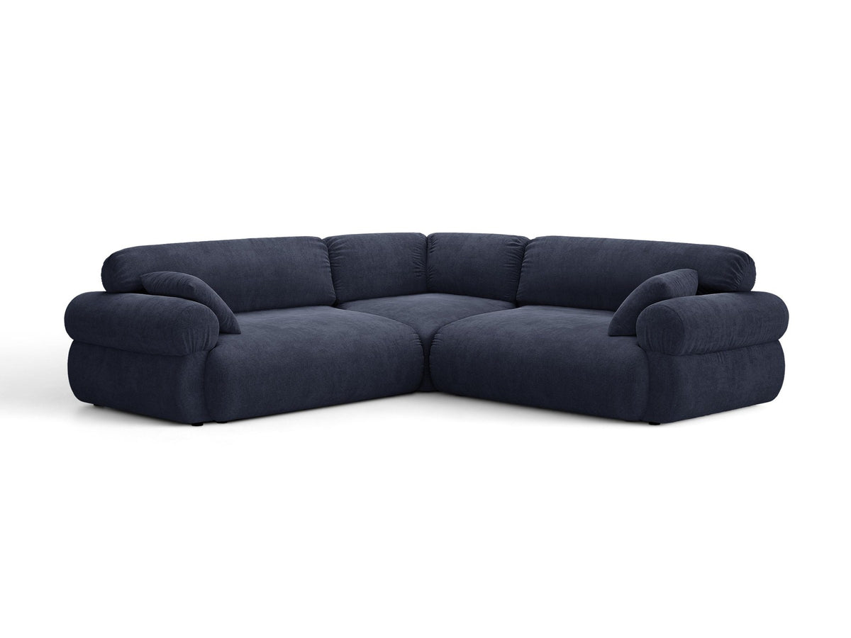 Beiges Ecksofa Ophelia von Micadoni mit Liberty-Stoff, schwarzen Kunststoffbeinen und niedriger, symmetrischer Silhouette im Wohnzimmer.