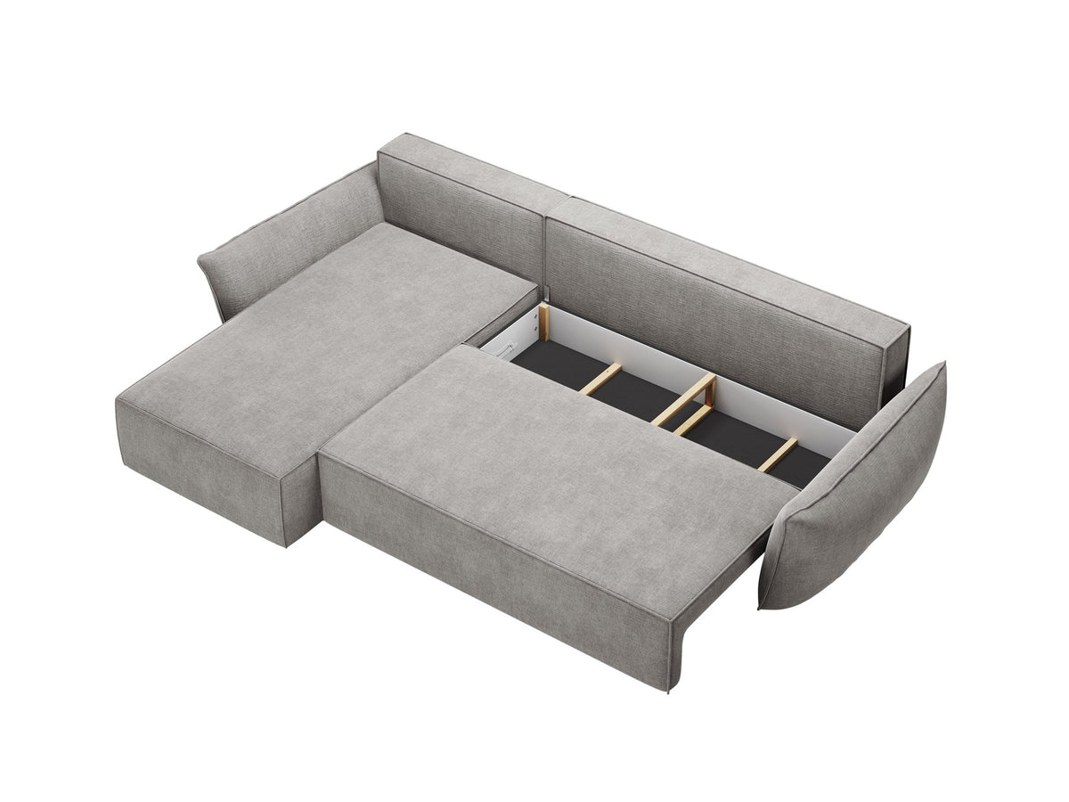 Linksseitiges Ecksofa Kaelle von Micadoni in leichtem Beige mit Chenille-Stoffbezug, schwarzen Kunststoffbeinen und ausklappbarem Bettkasten.