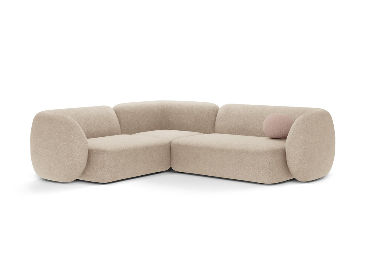 Weisses Ecksofa links Kate von Micadoni mit Bouclé-Stoff Baloo, schwarzen Kunststoffbeinen und niedriger Rückenlehne im Wohnraum.