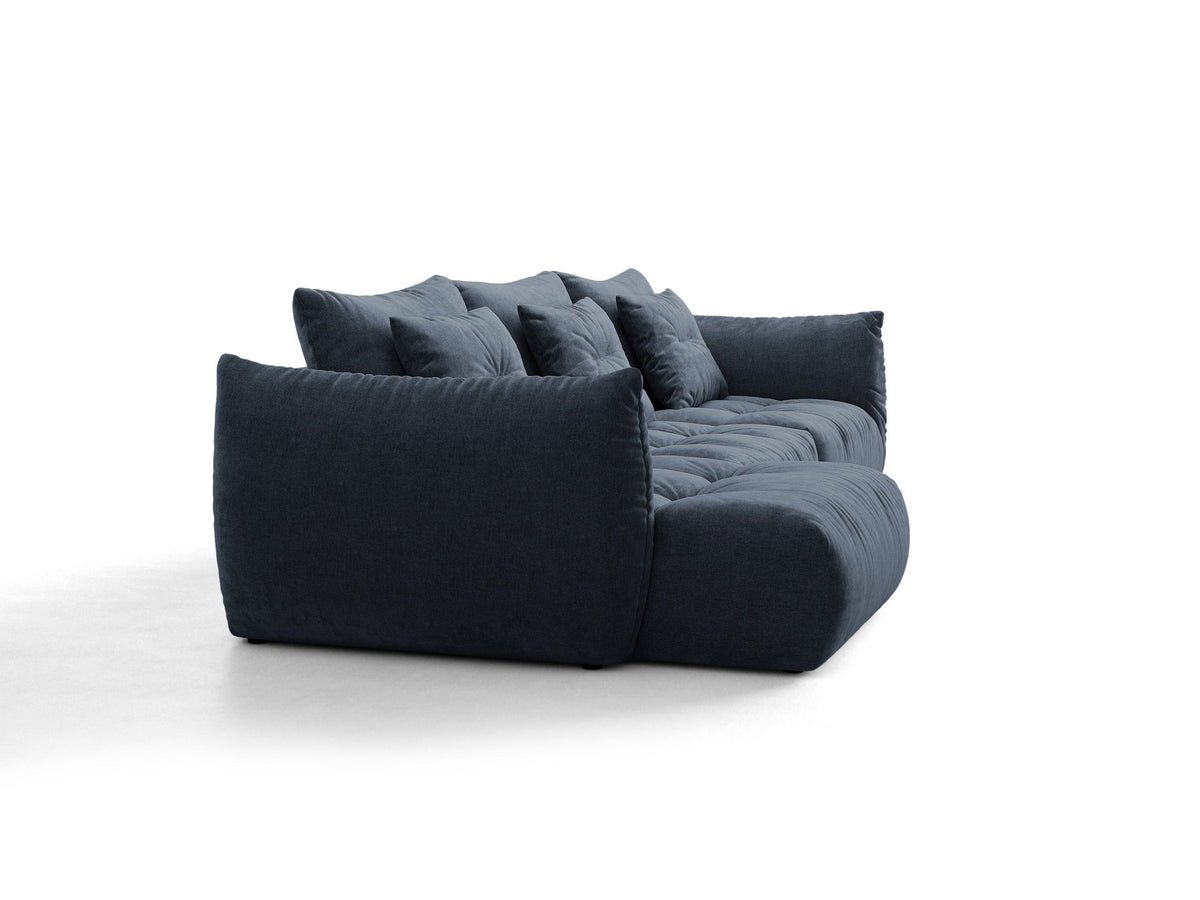 Beiges L-Sofa links von Micadoni mit weichem Veloursstoff Casino, schwarzen Kunststoffbeinen und breiter, tiefer Sitzfläche.